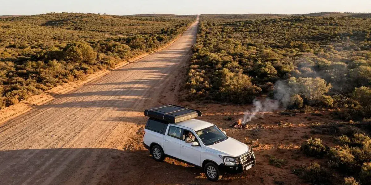 Long straight unsealed outback road stretching to the horizon in Western Australia